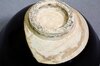 Unterseite einer schwarzen japanischen Teeschale Chawan mit rohem Tonteller und natürlicher Patina Unterseite einer schwarzen japanischen Teeschale Chawan mit rohem Tonteller und natürlicher Patina