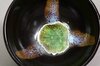 Nahaufnahme des Innenbodens einer japanischen Teeschale Chawan mit grünem Glasurzentrum und Dekorstreifen Nahaufnahme des Innenbodens einer japanischen Teeschale Chawan mit grünem Glasurzentrum und Dekorstreifen