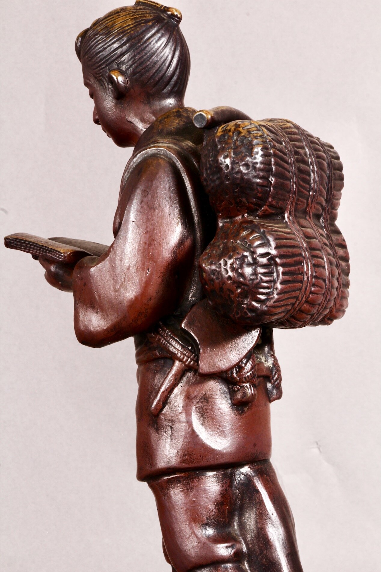 Bronze-Statue von Ninomiya Kinjirou im Profil – traditionell gekleidet mit Buch