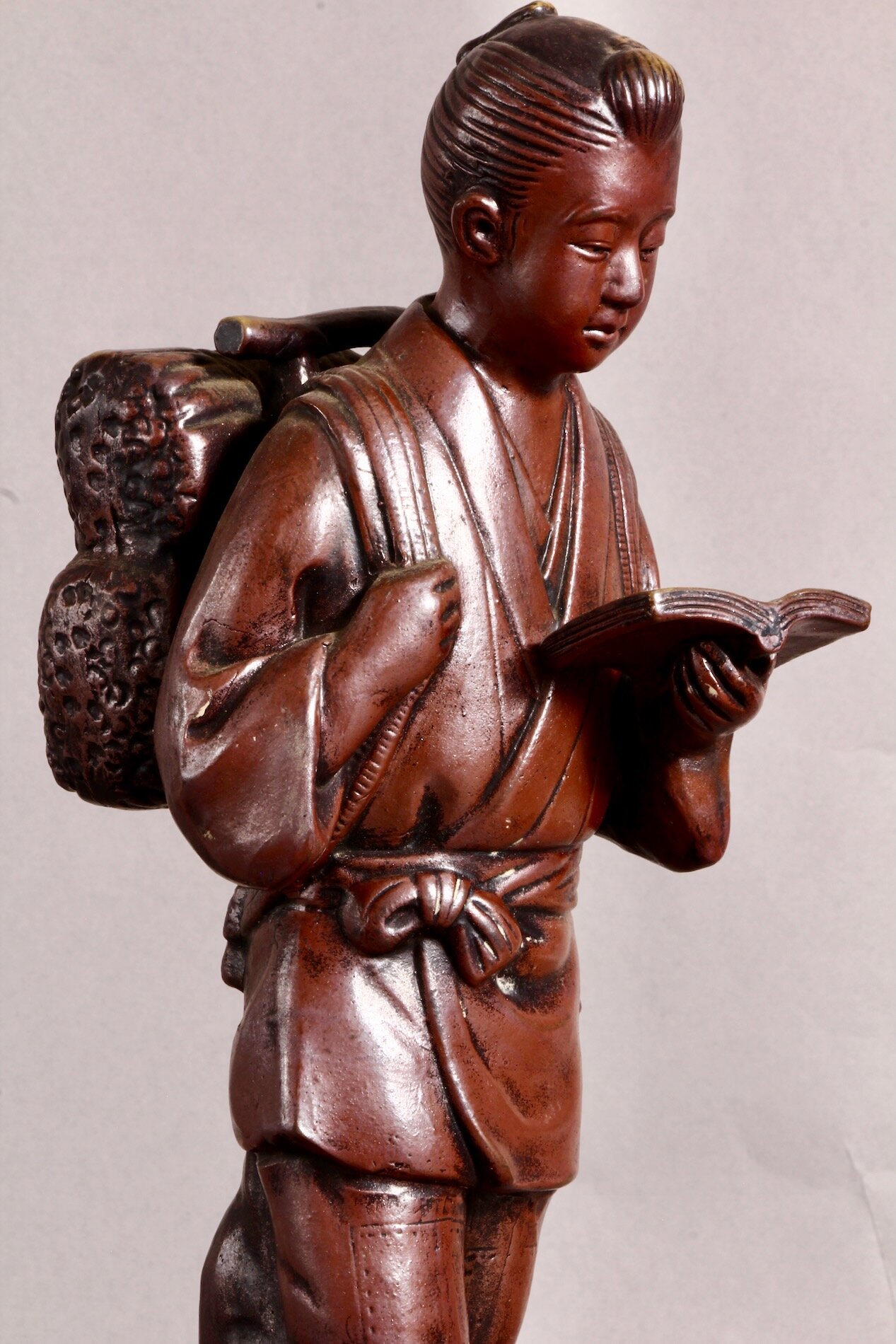 Nahaufnahme: Ninomiya Kinjirou mit Buch in der Hand – Symbol für Bildung und Fleiß