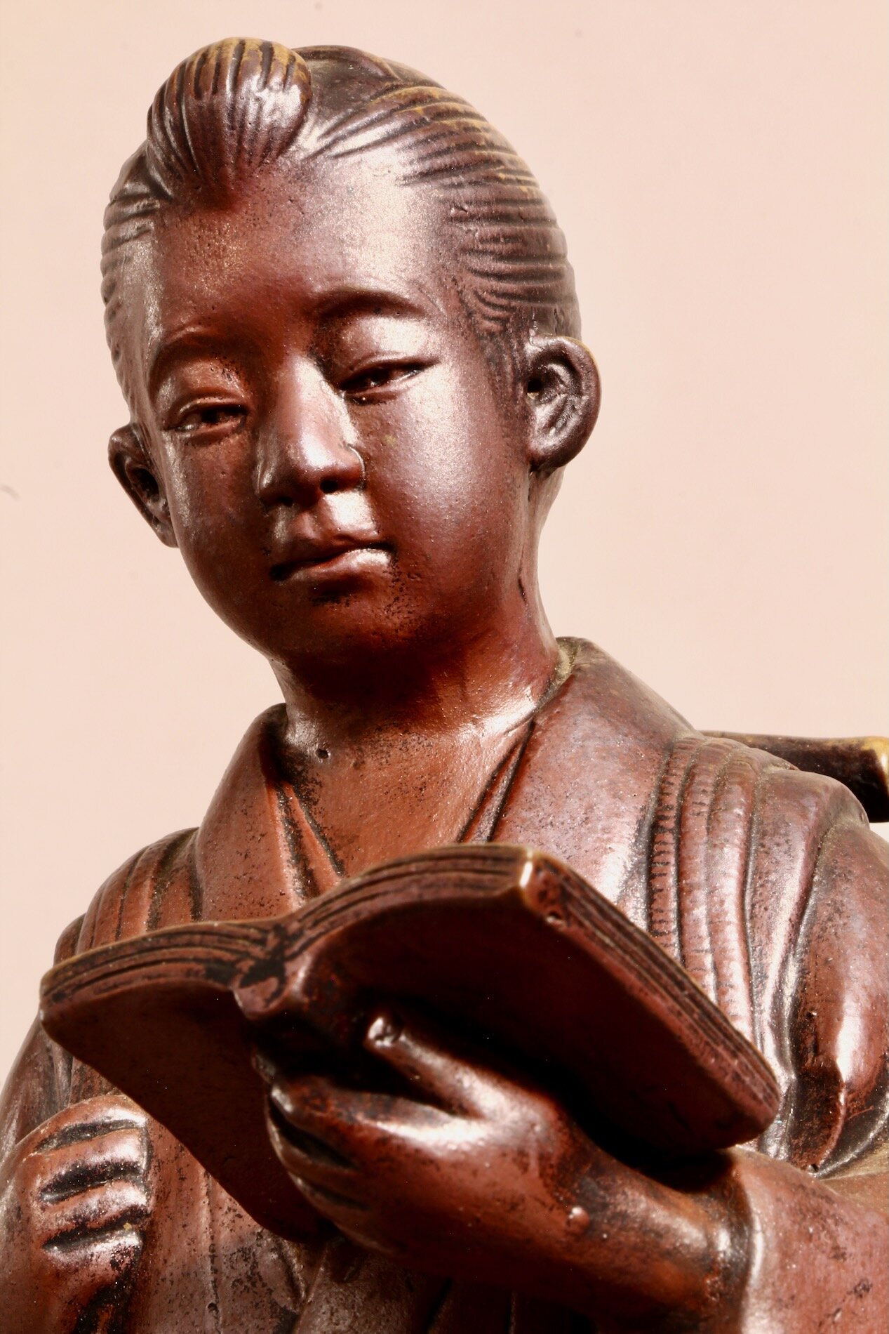 Ausdrucksstarkes Gesicht der Bronzestatue Ninomiya Kinjirou beim Lesen