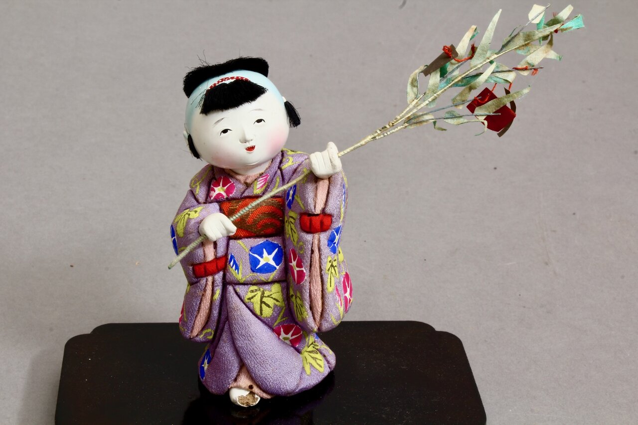 Kind mit Zweig in farbig besticktem Kimono aus Japan