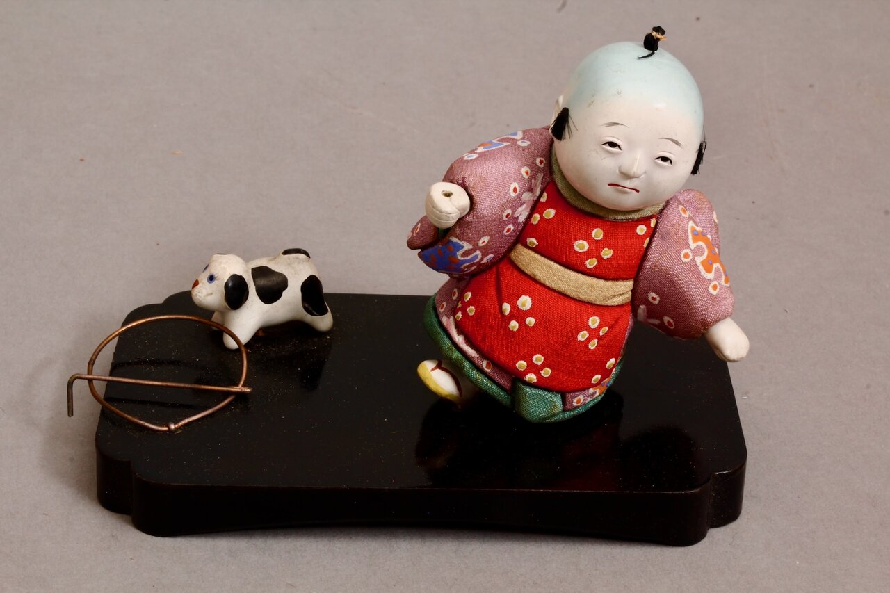 Japanische Kinderfigur beim Spielen mit Tierfigur