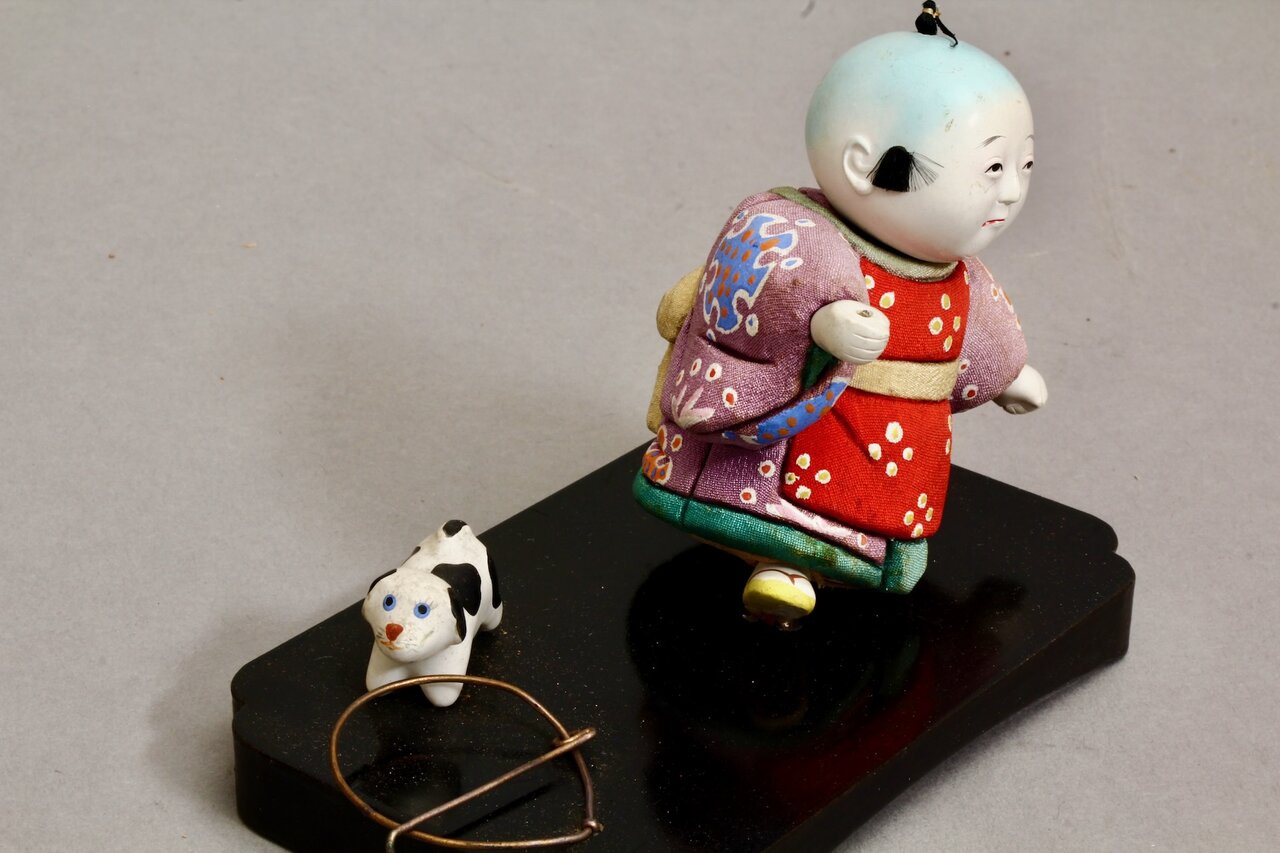 Kindliche Spielszene mit Kimono-Figur und kleinem Tier
